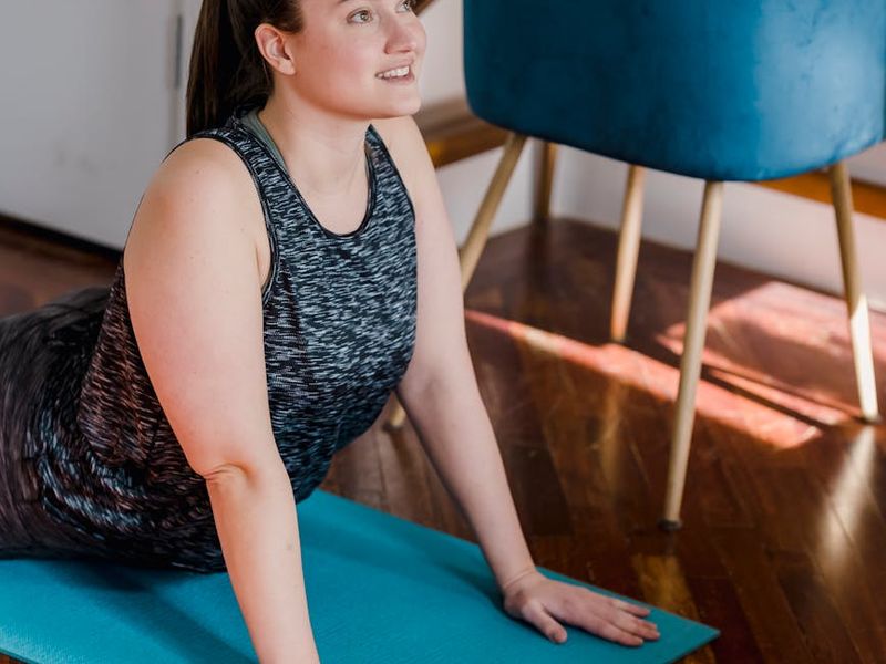 Main photo showing a person in a deep, focused yoga stance in a bright, airy room.